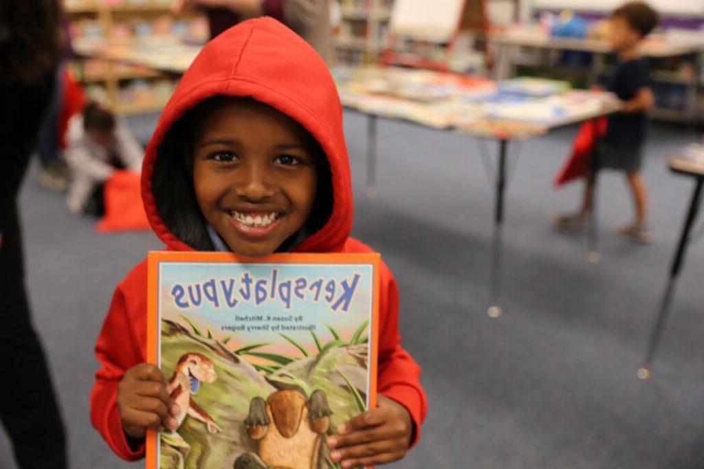 A smiling boy holding a book